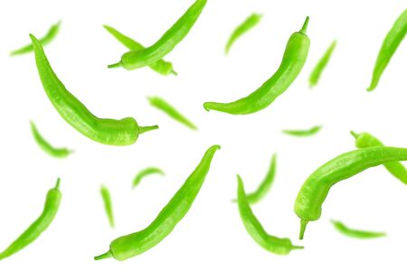 Falling green hot peppers isolated on a white background    as package design element and advertising. Flying vegetables. Top view.の写真素材