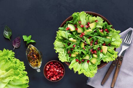 Avocado and pomegranate salad on a dark background. Healthy vegetarian food. Top viewの写真素材
