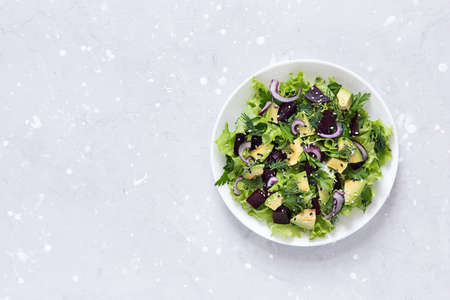 Healthy vegetarian salad of avocado, beetroot and greens in a white bowl. Top view, copy space.の写真素材