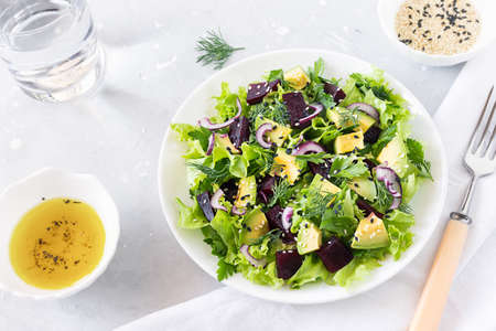 Healthy vegetarian salad of avocado, beetroot, greens and sesame in a white bowl. Top viewの写真素材