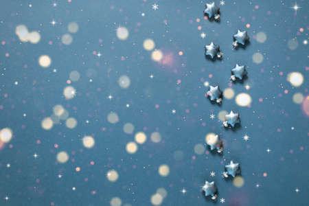 Christmas decorative stars on a blue background with bokeh lights. Holiday greeting cardの写真素材