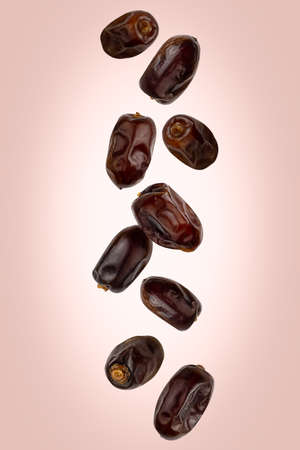 Falling delicious dates are isolated on a colored backgroundの写真素材