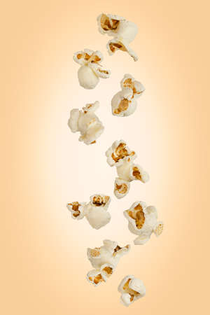 Falling popcorn are isolated on a colored background with as package design element and advertisingの写真素材