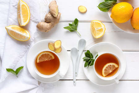 Antioxidant healthy tea with lemon, ginger and mint on a white wooden table. Alternative medicine concept. Top viewの写真素材