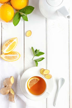 Antioxidant healthy tea with lemon, ginger and mint on a white wooden table. The concept of alternative medicine. Top viewの写真素材