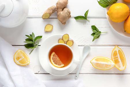 Antioxidant healthy tea with lemon, ginger and mint on a white wooden table. Alternative medicine concept. Top viewの写真素材