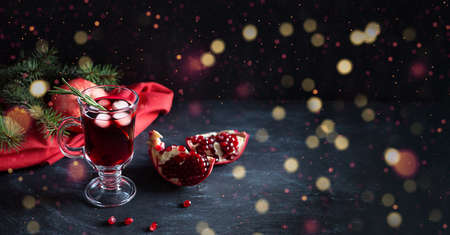 Pomegranate Christmas cocktail with rosemary, champagne, club soda on black table with bokeh lights. Xmas drink. Bannerの写真素材