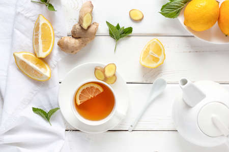 Antioxidant healthy tea with lemon, ginger and mint on a white wooden table. Alternative medicine concept.の写真素材