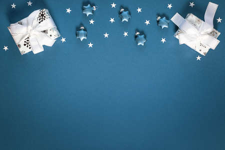 Christmas background with gift white boxes, toys and decorative shiny stars on blue. New year giftの写真素材