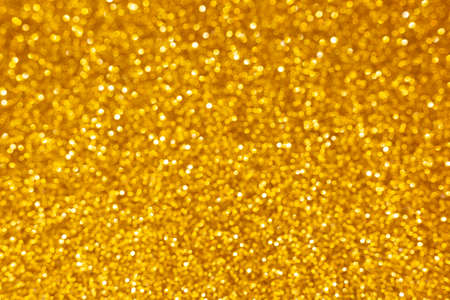 Golden abstract defocused bokeh background. Sparkling textureの写真素材