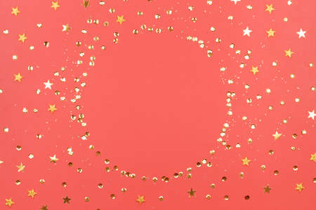 Coral background with glitter and golden stars. Sparkling texture. Festive backdrop for your projects.の写真素材