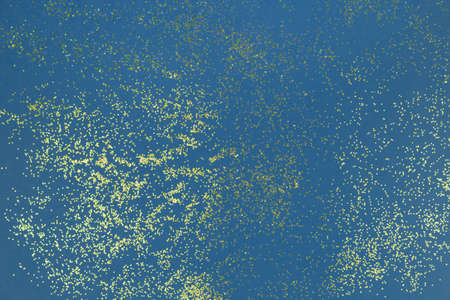 A splash of Golden sparks on a blue. Confetti background. Sparkling texture. Festive backdrop for your projects.の写真素材