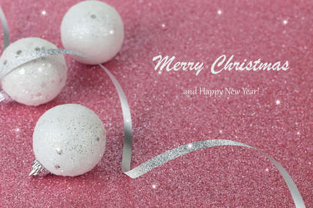 Christmas white balls on a pink sparkling background. New year card. Shiny texture. Selective focus.の写真素材