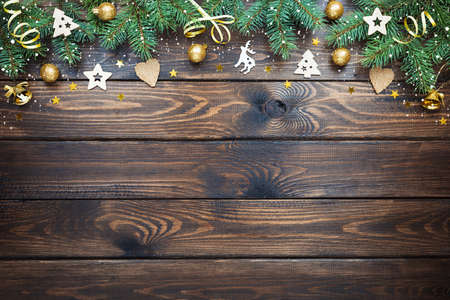 Christmas background with wooden ornaments, Golden balls and bells on a wooden table. New year card. Copy space, flat lay, top view.の写真素材