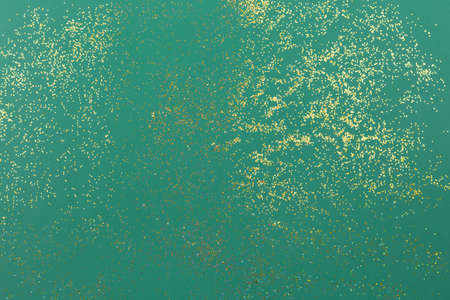 Confetti background. A splash of Golden sparks on a green. Sparkling texture. Festive backdrop for your projects.の写真素材