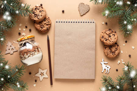 Craftbook, Notepad for wishes. Homemade Mix for making chocolate oatmeal cookies in a glass jar on a beige backgroundの写真素材