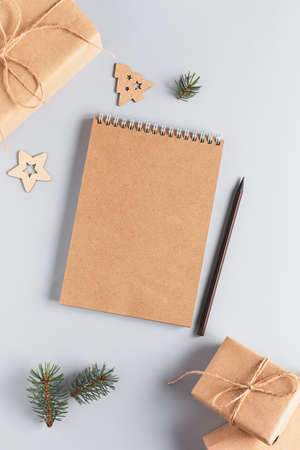 Christmas background with blank notebook, gift boxes in craft paper, fir branches and decorations. Zero waste conceptの写真素材