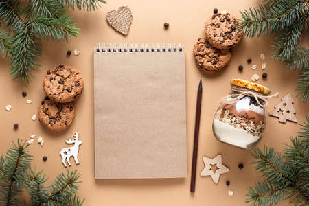 Craftbook, Notepad for wishes. Homemade Mix for making chocolate oatmeal cookies in a glass jar on a beige backgroundの写真素材
