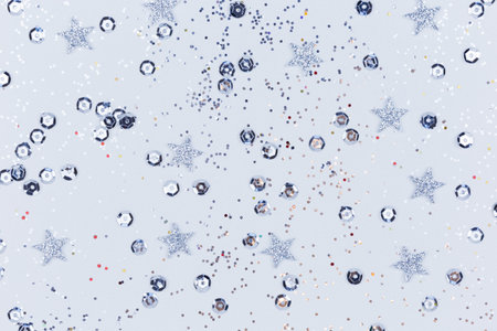 Shiny silver stars and sequins on a gray background. Festive sparkling textureの写真素材