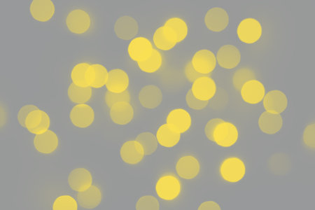 Golden bokeh background. Bright blurred texture of lights. Trendy colors 2021 - Gray and Yellow.の写真素材