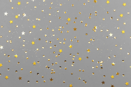 Gray background with glitter and golden stars. Sparkling texture. Festive backdrop for your projectsの写真素材