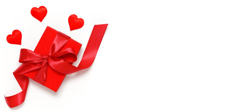 Red gift box tied with a ribbon with decorative hearts on a white background. Gift for Valentine's Day, Birthday, Mother's Day or International Women's Dayの写真素材