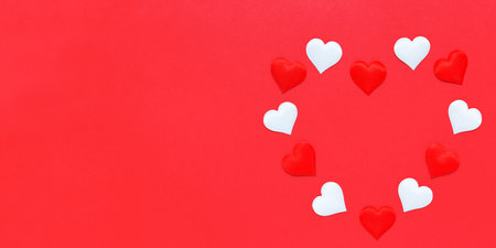 Decorative small red and white hearts are laid out in the shape of a large heart on a red background. Bannerの写真素材