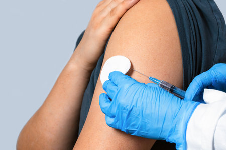 Close up of a Doctor making a vaccination in the shoulder of patient. The concept of a coronavirus vaccine. Vaccination of people.の写真素材