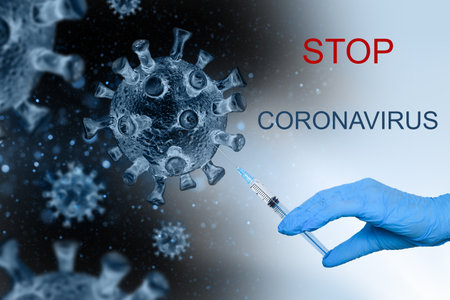 A doctor's hand with a syringe injecting a vaccine into the COVIND-19 virus. Coronavirus vaccine, syringe injection, prevention, immunization, treatment of coronavirus infection.の写真素材