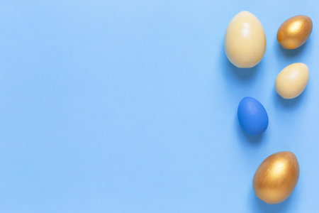 Colorful Easter eggs on a blue background. Flat lay, a copy of space. Easter decoration, modern design pattern.の写真素材