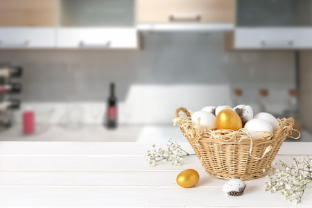 Basket with colorful eggs on kitchen wooden tabletop. Spring easter composition. Space for text or designの写真素材