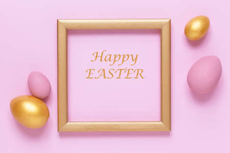 Gold and pink Easter eggs on pink pastel background, gold frame with space for text, flat lay image compositionの写真素材