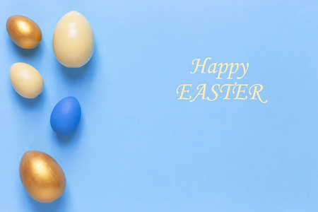 Colorful Easter eggs on a blue background. Flat lay, a copy of space. Easter decoration, modern design patternの写真素材