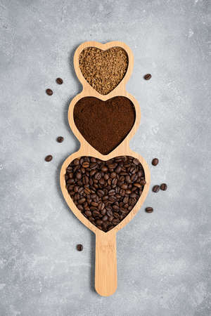 Coffee beans, ground and instant coffee on a wooden stand on a gray background. Top view, copy spaceの写真素材