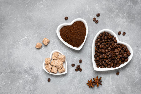Coffee beans, ground coffee and brown sugar cane in white plates on a gray background. Top view, copy spaceの写真素材
