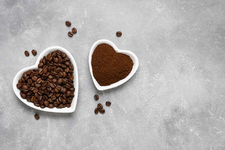 Coffee beans, ground coffee in white plates on a gray background. Top view, copy spaceの写真素材