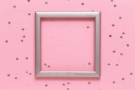 Silver frame layout with space for text and confetti on a pink background. Flat lay, top view....