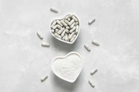 Collagen powder and tablets on a gray background with a copy space. Natural beauty and health supplement.の写真素材