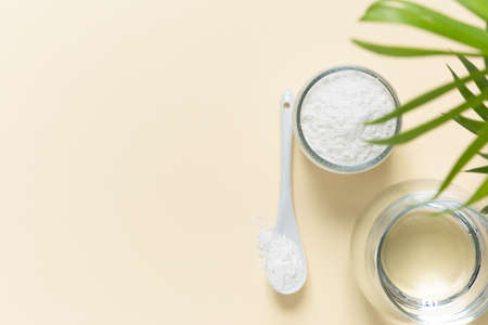 Collagen powder and a glass of water on a beige background with a copy space. Extra protein intakeの写真素材