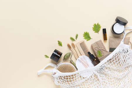 Zero waste, eco friendly bathroom accessories and personal care in a cotton string bag on beige background. Natural organic eco cosmetics. Layout of the beauty salon branding. Flat lay, top view.の写真素材