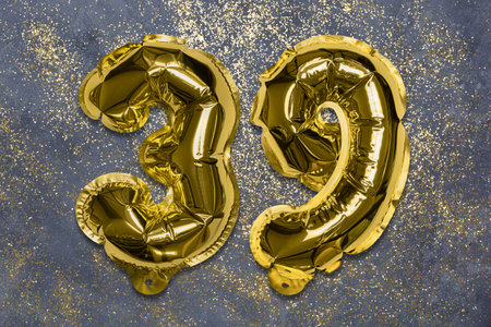 The number of the balloon made of golden foil, the number thirty-nine on a gray background with sequins. Birthday greeting card with inscription 39. Numerical digit, Celebration event, template.の写真素材
