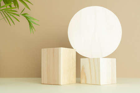 Wooden podiums, pedestals on a beige background with palm leaves. Showcases for the promotion of products, beauty, natural cosmetics. Abstract minimalistic elegant studio stage.の写真素材