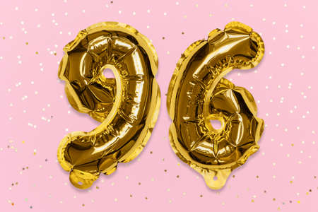 The number of the balloon made of golden foil, the number ninety-six on a pink background with sequins. Birthday greeting card with inscription 96. Numerical digit, Celebration event, template.の写真素材