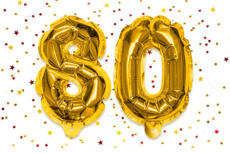 The number of the balloon made of golden foil, the number eighty on a white background with...