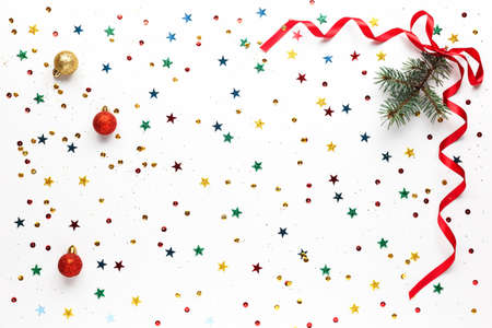 Festive Christmas gold, red decorations, multicolored sequins and a twig of a Xmas tree with a bow...