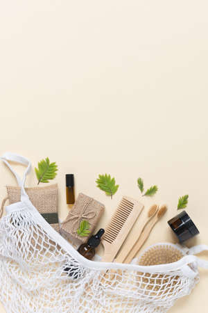 Zero waste, eco friendly bathroom accessories and personal care in a cotton string bag on beige background. Natural organic eco cosmetics. Layout of the beauty salon branding. Flat lay.の写真素材