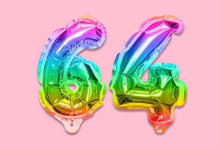 Rainbow foil balloon number, digit sixty four on a pink background. Birthday greeting card with inscription 64. Top view. Numerical digit. Celebration event template.の写真素材
