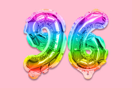 Rainbow foil balloon number, digit ninety six on a pink background. Birthday greeting card with inscription 96. Top view. Numerical digit. Celebration event template.の写真素材