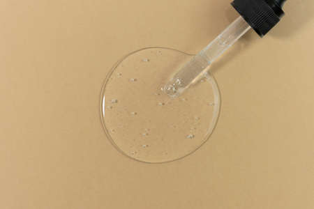 The texture of serum or oil with a pipette on a beige background. wellness and beauty concept.の写真素材