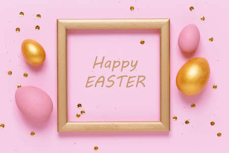 Golden and pink Easter eggs on pink pastel background with sequins. Gold frame with space for text, flat lay image composition, top view. Easter decoration, modern design template.の写真素材